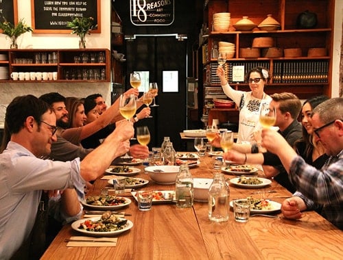 A photo of people toasting drinks at dinner