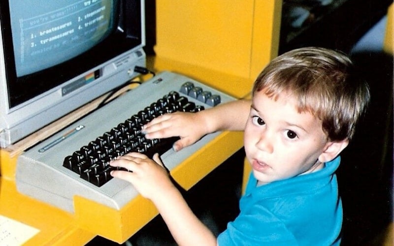 Toddler sitting at a computer.