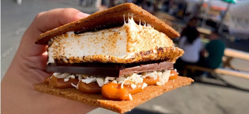 An ooey gooey smore with melty marshmallow and caramel