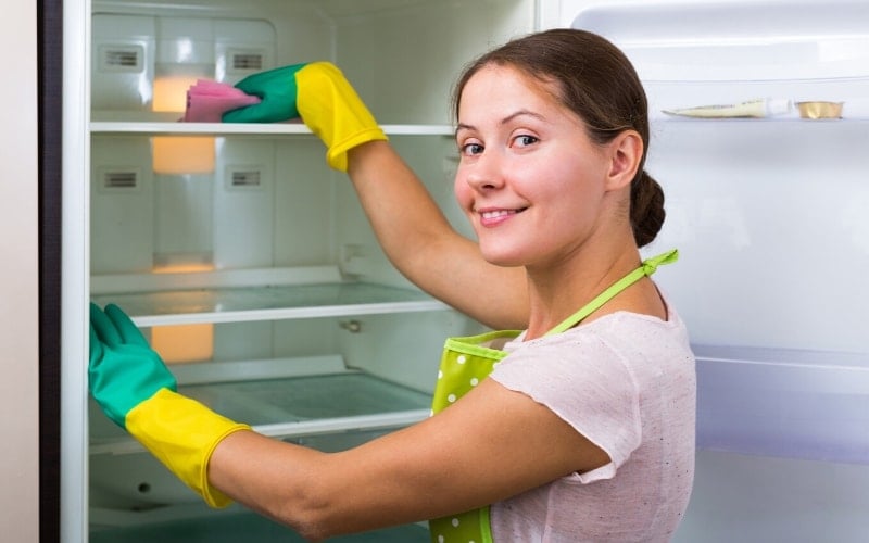 photo of person cleaning a fridge in anticipation of a virtual happy hour activity