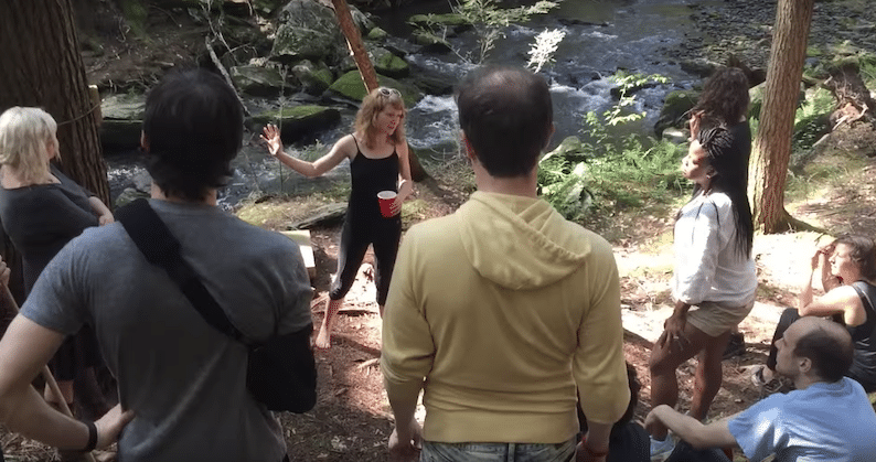 Tour guide explaining to a group in front of a forest exhibit